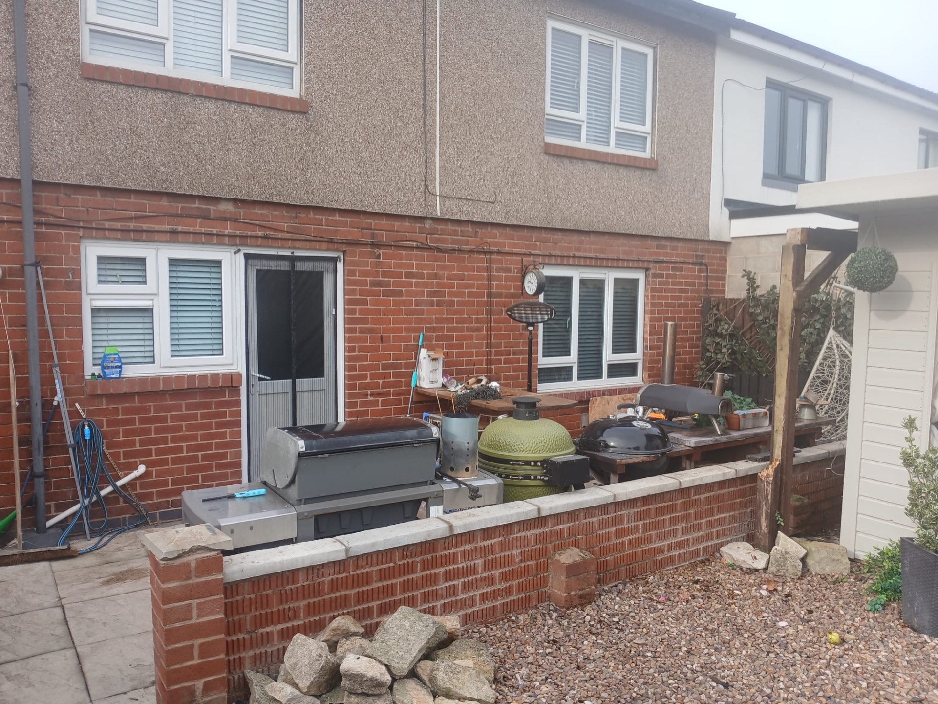 Outdoor kitchen and barbecue setup under a rear canopy